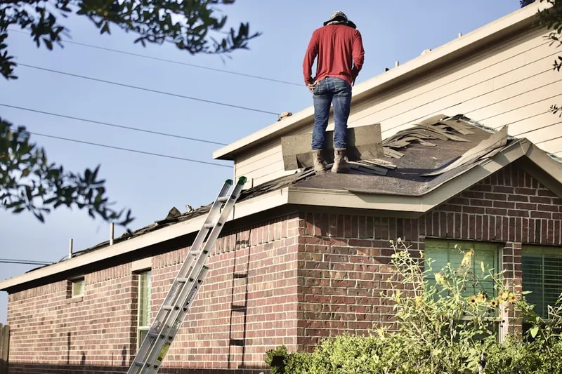 Professional roofer working on a residential roof in Van Buren
